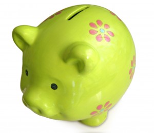 How Can You Save Money - This is the Easiest Way A bright green ceramic piggy bank adorned with pink and red flower designs.