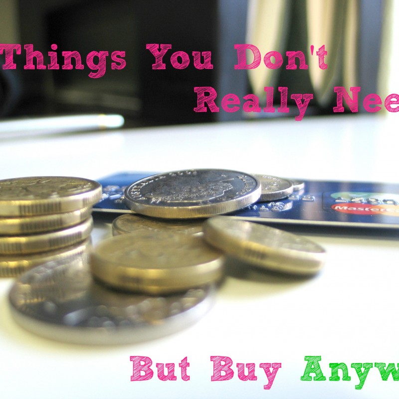 A stack of coins and a credit card rest on a white surface. The text overlaid on the image reads: "7 Things You Don't Really Need But Buy Anyway" in pink and green font—a humorous take on discovering new ways to save money.