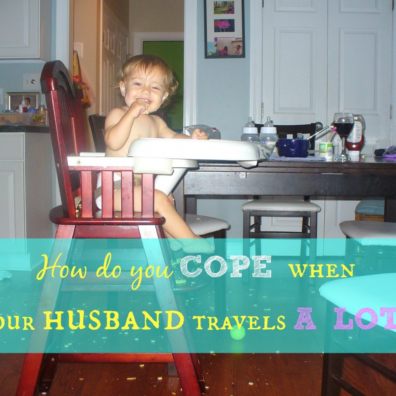 A smiling toddler sits in a high chair at a dining table with a cluttered kitchen in the background. The text overlay reads, "How do you cope when your traveling spouse is away often?