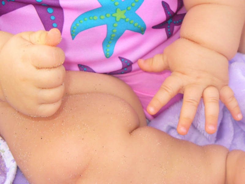 up close sandy baby hands at the beach