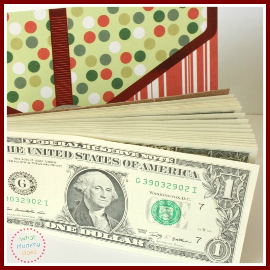 A notepad made of real one dollar bills in front of a coupon holder with green, white and red polka dots. 