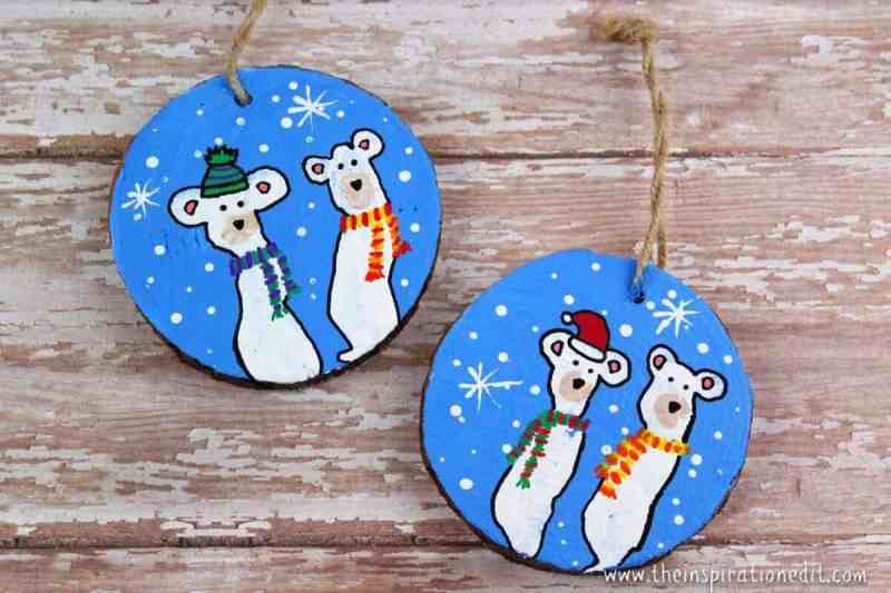 two christmas ornaments with a blue background, with white polar bears wearing scarves on the front.