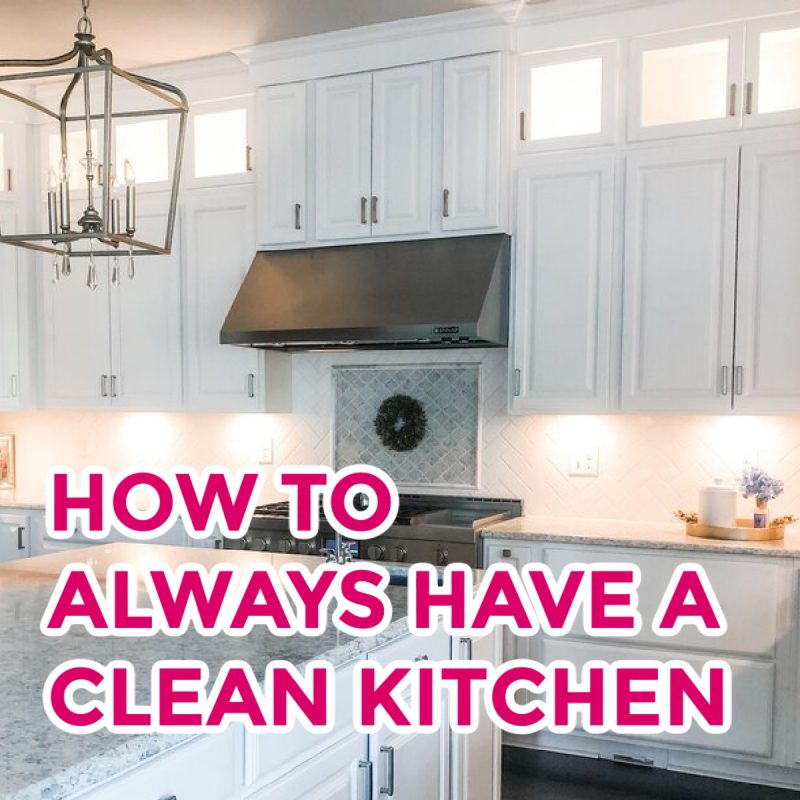 A modern kitchen with white cabinets, marble countertops, and stainless steel appliances. A chandelier hangs from the ceiling. The text "HOW TO ALWAYS MAINTAIN A CLEAN KITCHEN" is prominently displayed in bold pink and white letters over the image.
