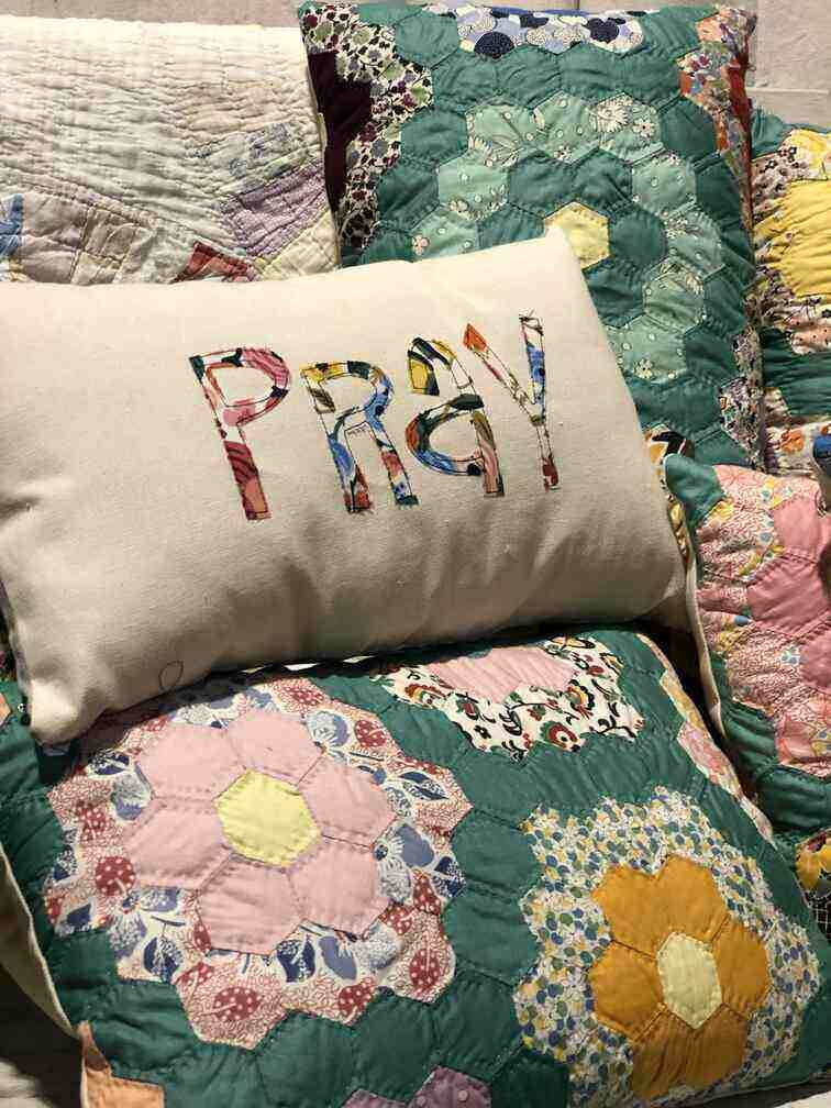 throw pillow ith the word PRAY on it made from a quilt.
