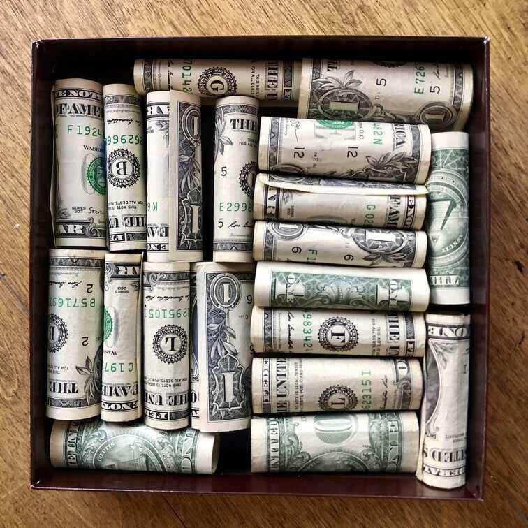 https://www.whatmommydoes.com/wp-content/uploads/2021/08/how-to-roll-up-dollar-bills-for-this-box.jpg