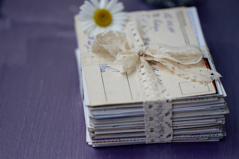 stack of letters tied with lace ribbon with chamomile