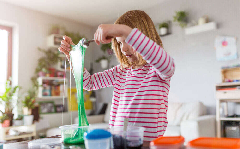 young girl playing with slime in a kitchen