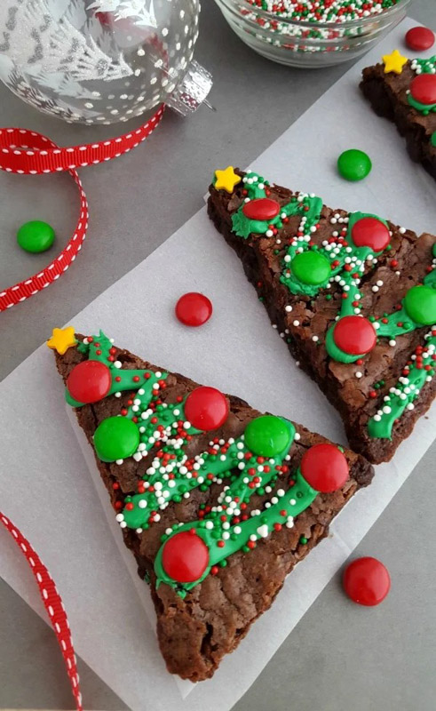 brownies cut into the shape of Christmas trees with icing, sprinkles and m&m's as ornaments