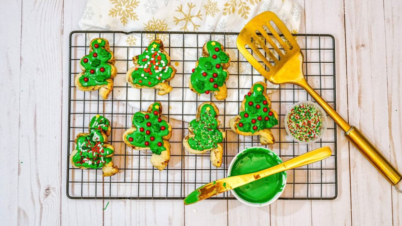 cinnamon rolls shaped into Christmas trees with green icing on top