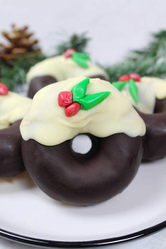 a chocolate covered donut with candies to make it look like a wreath