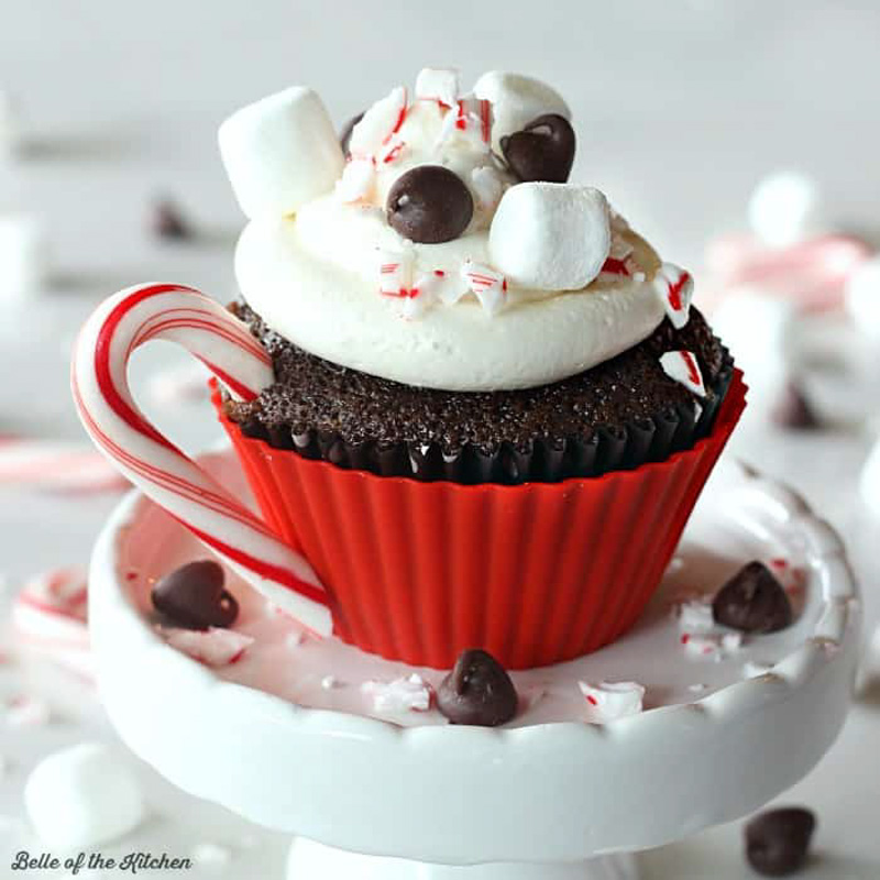 a cupcake that looks like a cup of hot chocolate with a candy cane handle