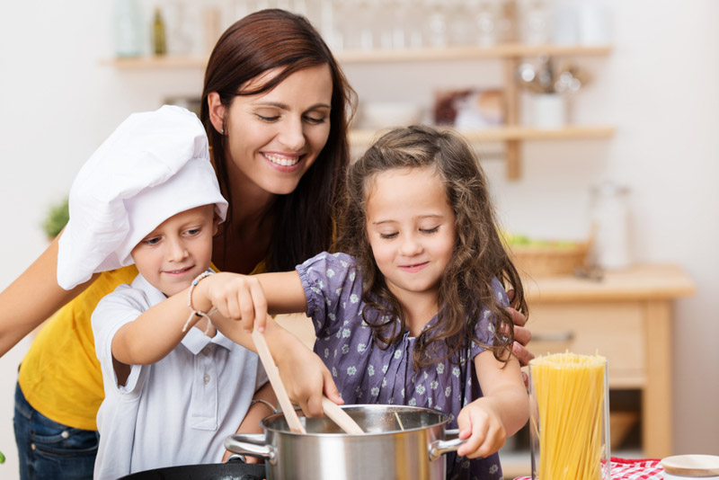 Mom with 2 kids enjoying a cooking lesson as an experience gift for kids