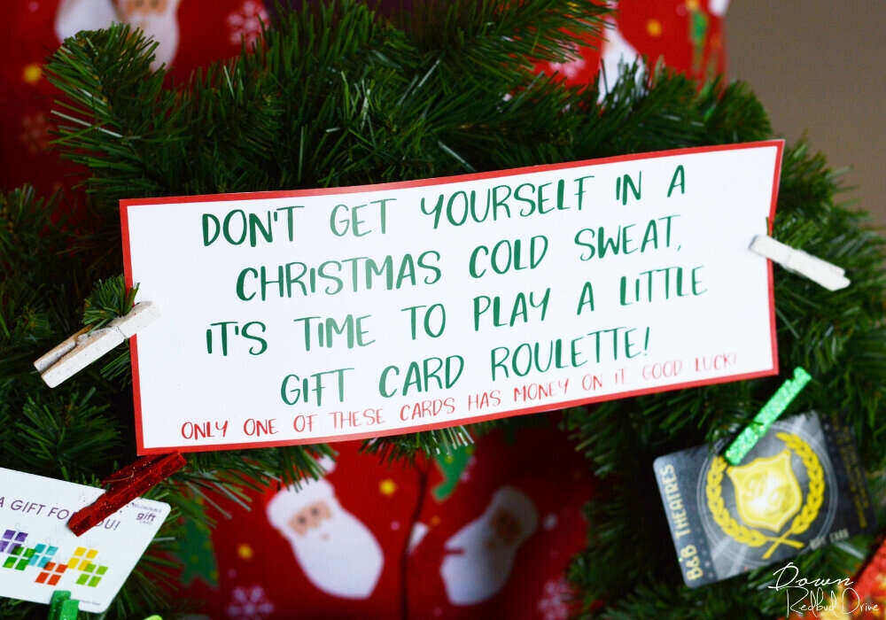 up close pic of a gift card wreath sign that reads "don't get yourself in a Christmas cold sweat...it's time to play a little gift card roulette!"