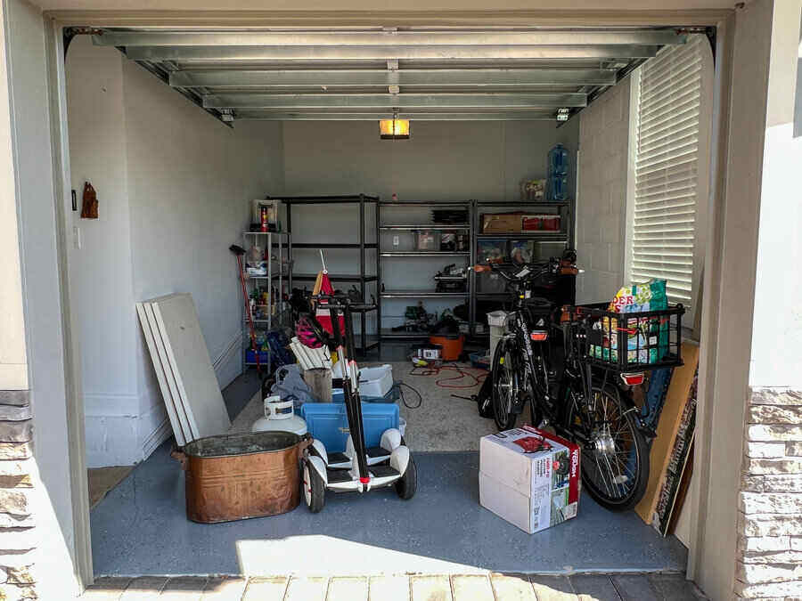 An unorganized garage filled with a lot of stuff in a neighborhood