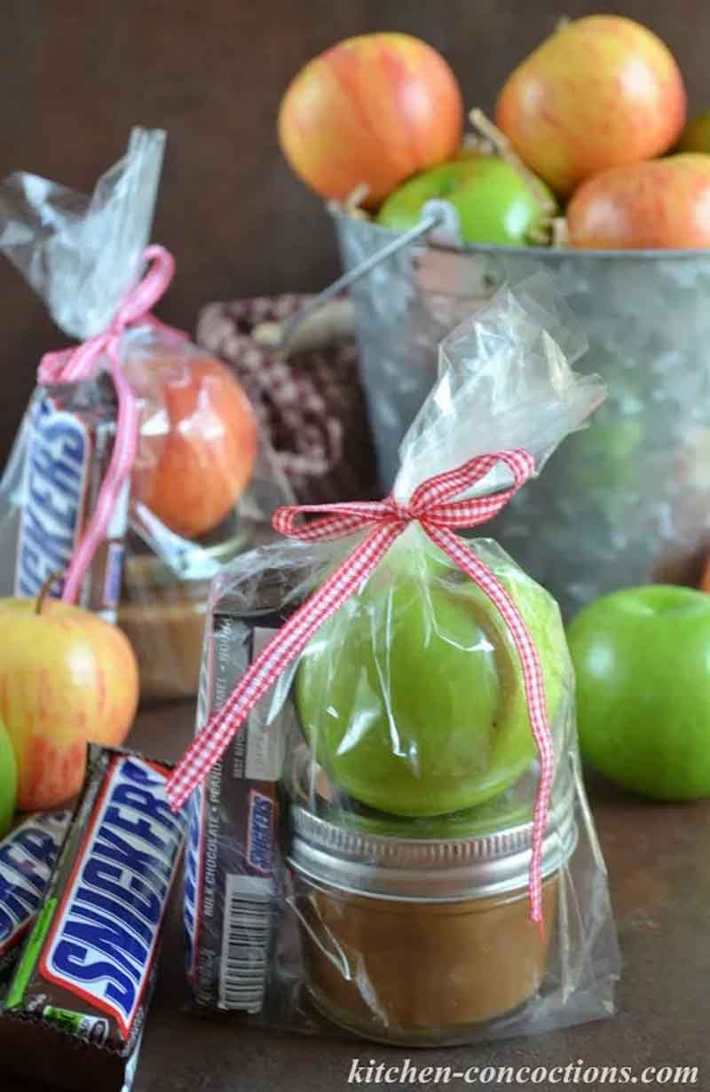 small clear bags with homemade caramel, a snickers bar and granny smith apple inside