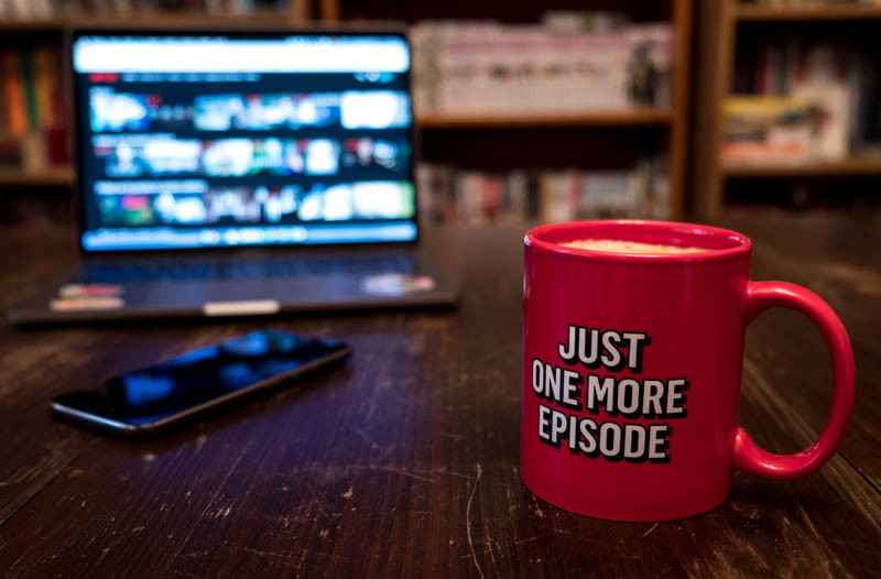 funny red mug on a table and netflix open on a laptop