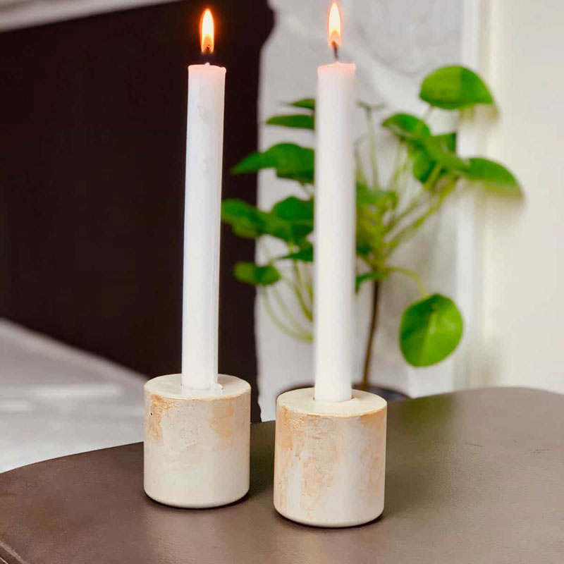 two concrete candle holders with white lit candles inside, made from a plastic water bottle