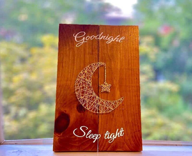 small wooden string art displayed on a window ledge