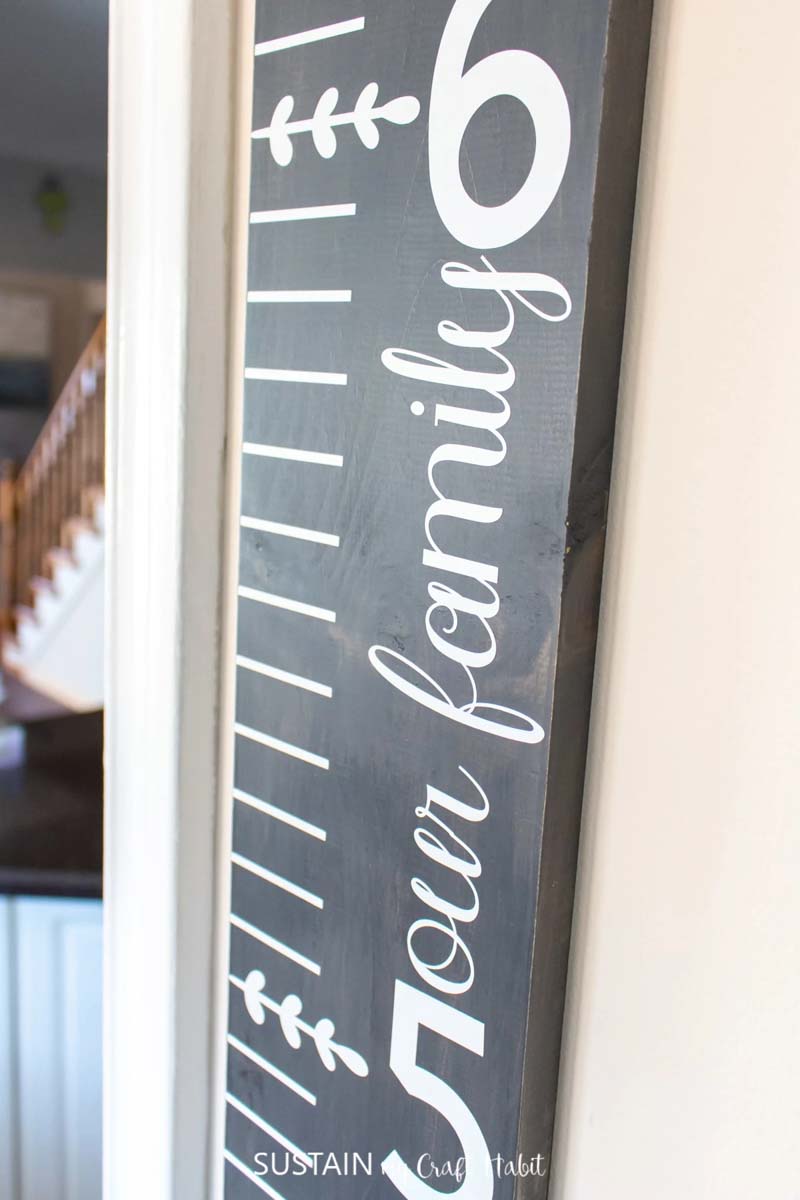 wooden growth chart with white lettering and markings