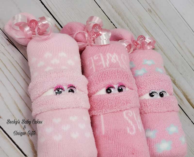 pink socks with rolled up diaper inside and googley eyes on it to look like a little baby for unique diaper gift ideas