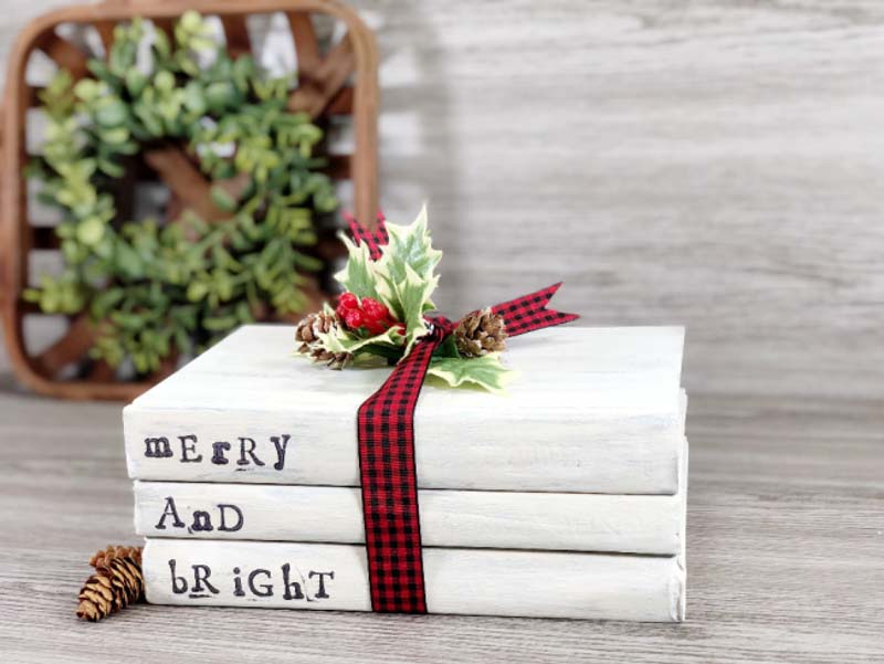 3 books stacked withe words Merry and Bright stamped onto the spines; tied together with a ribbon