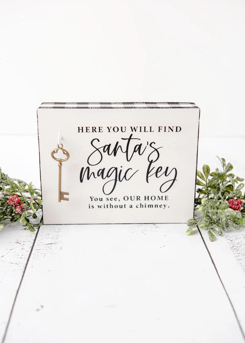 decorative sign with Santa quote and gold key attached