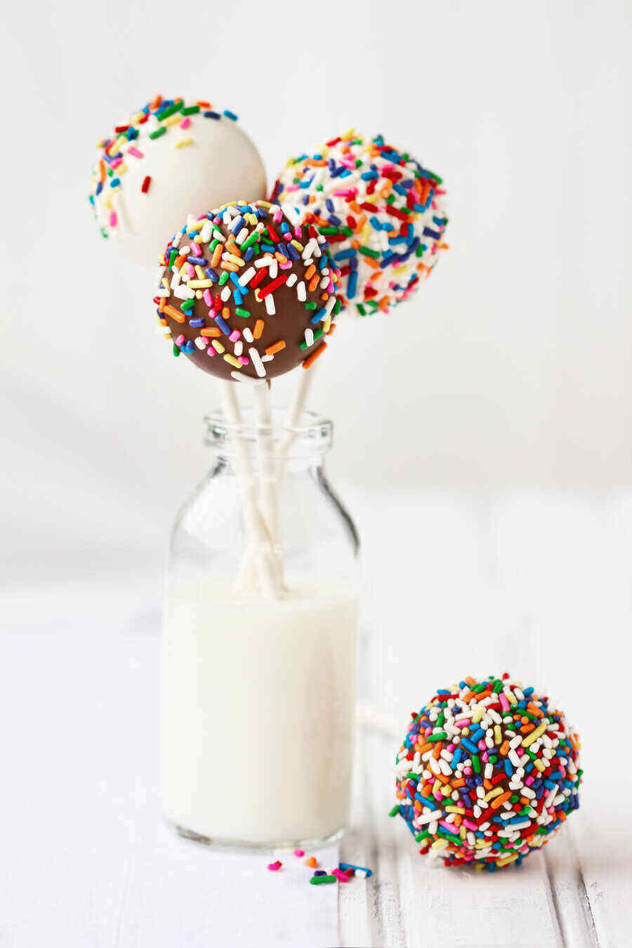 Chocolate covered cake pops decorated with colorful sprinkles