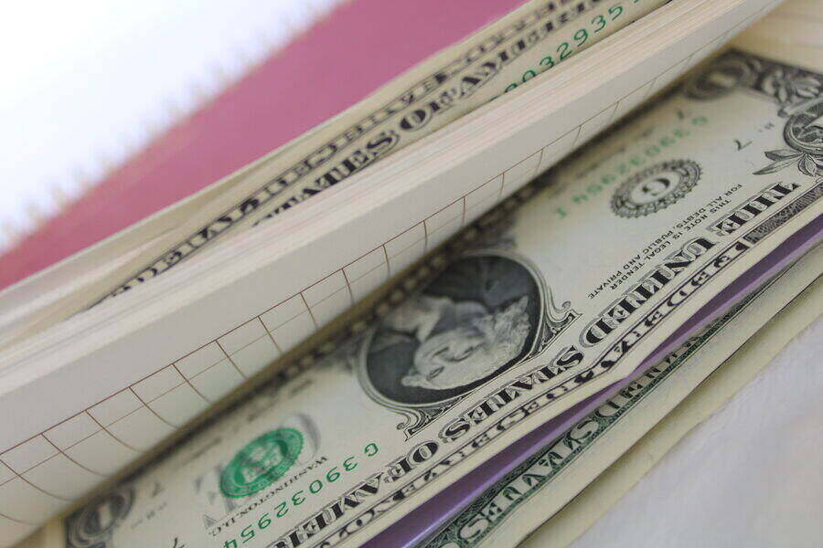 a pink notepad or journal that cash tucked into the pages to be given as a gift