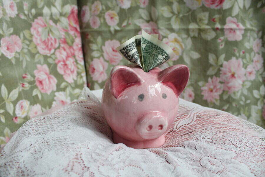 cute vintage piggy bank sitting on a lace pillow