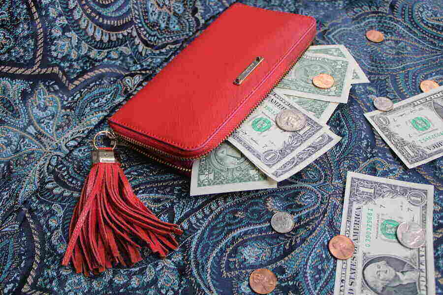 red wallet with red tassel holding cash