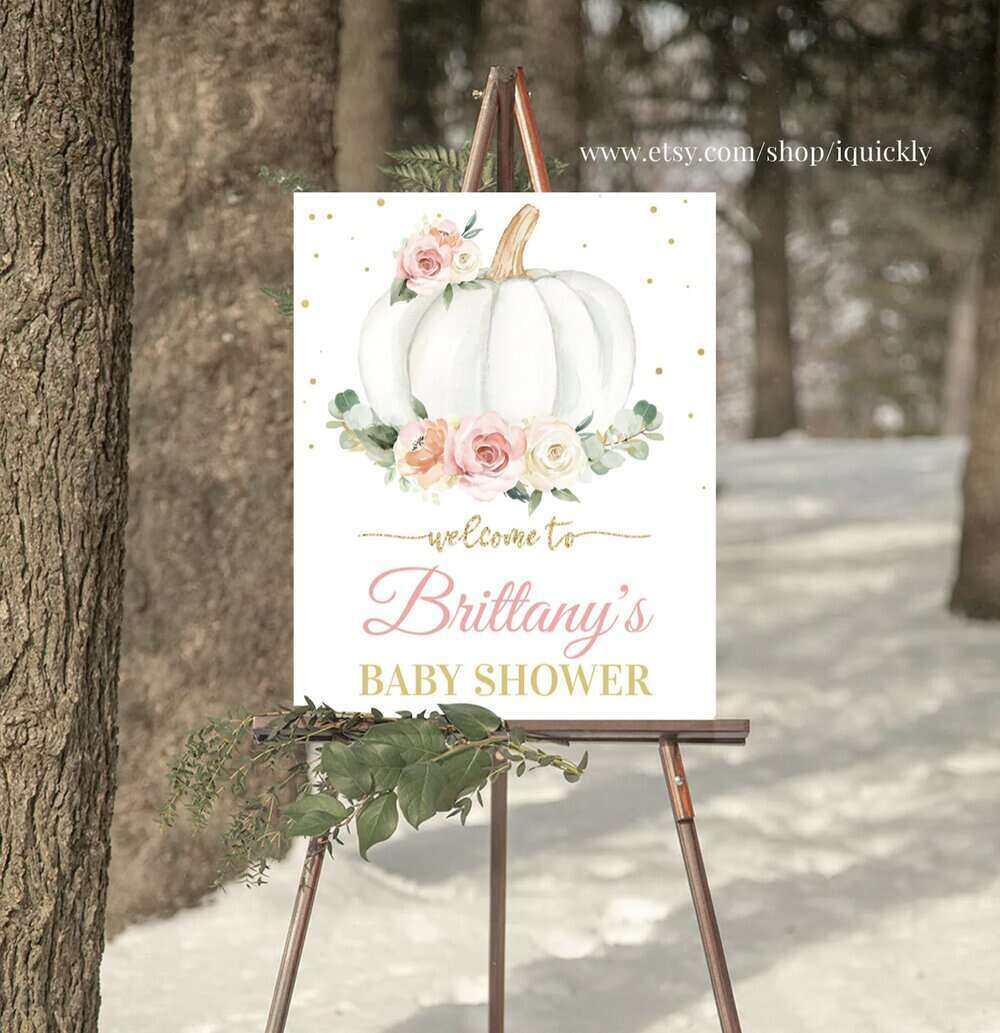 A large sign outdoors on an easel. The sign has a large white pumpkin with floral accents and welcomes people to a baby shower. 