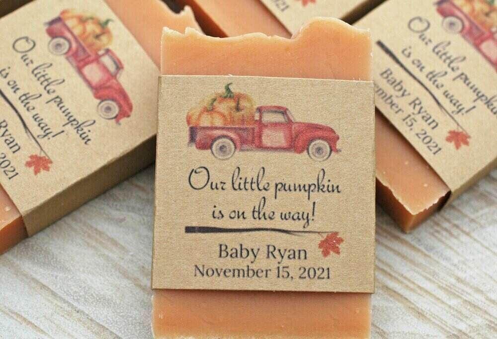 A photo overlay with an orange soap bar with a wrap that says our little pumpkin is on the way for a baby shower. 