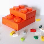 Two gift boxes wrapped in orange to resemble giant lego blocks.