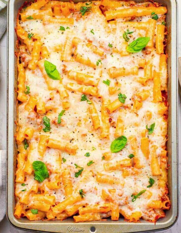 A casserole dish with delicious ziti noodles covered with cheese. 
