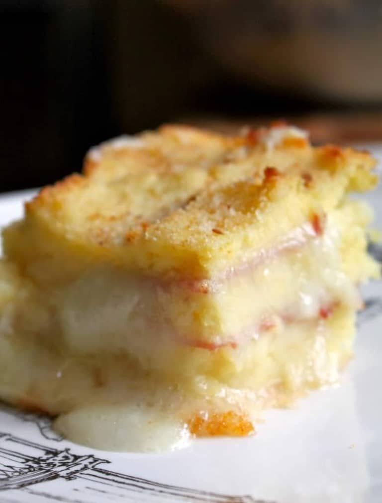 A plate with a slice of cheesy Potato ham casserole. 