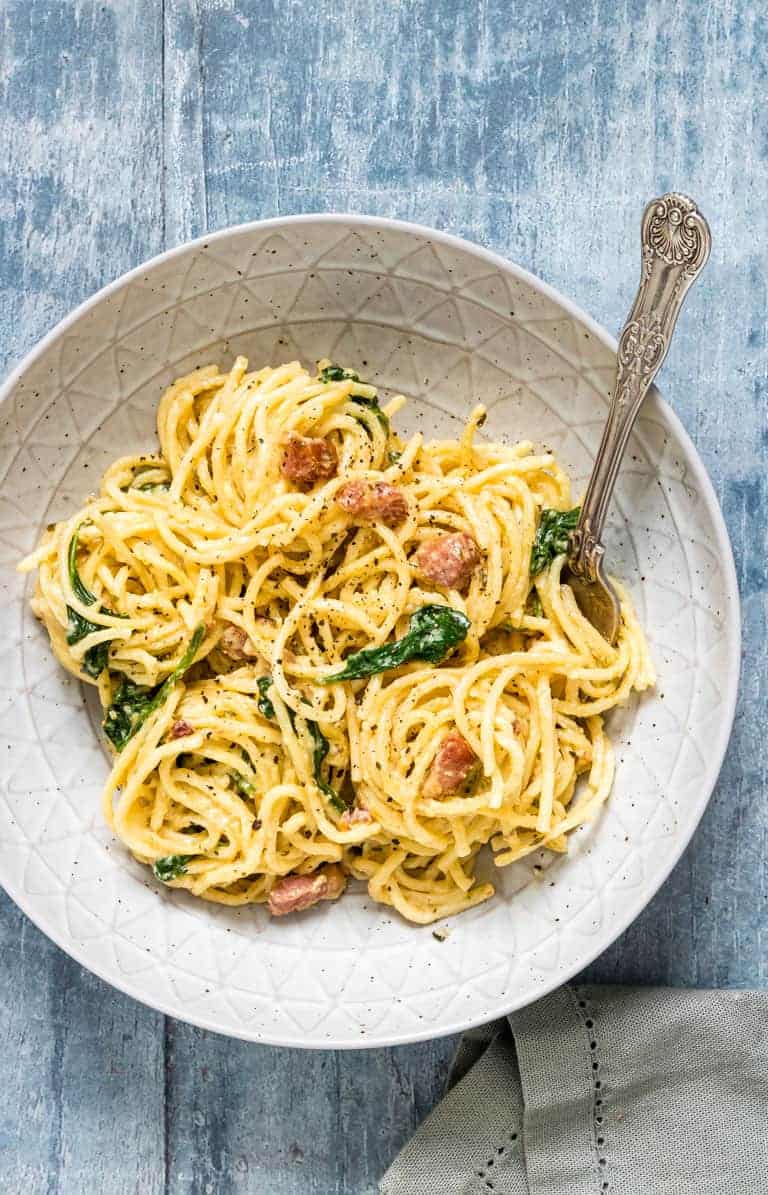 A white plate filled with pasta noodles and sauce.