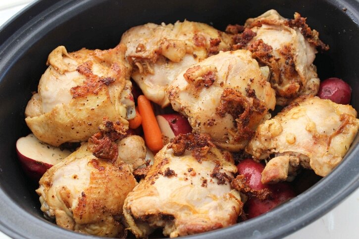 A Pot with Chicken Thighs, carrots and potatoes. 