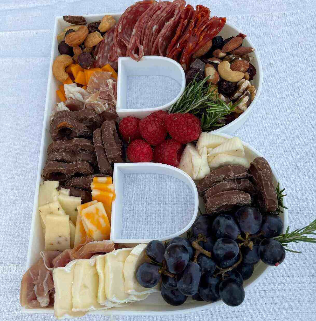 The Letter B shaped tray filled with cheese, nuts, and fruit for a cute charcuterie board