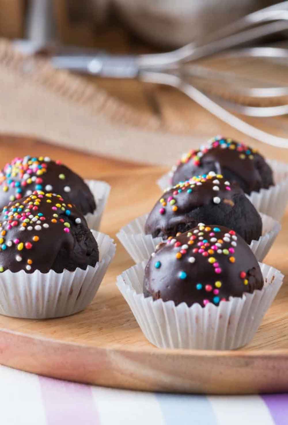 Chocolate cream cheese truffles with rainbow sprinkles in white wrappers, delicious homemade baby shower desserts.