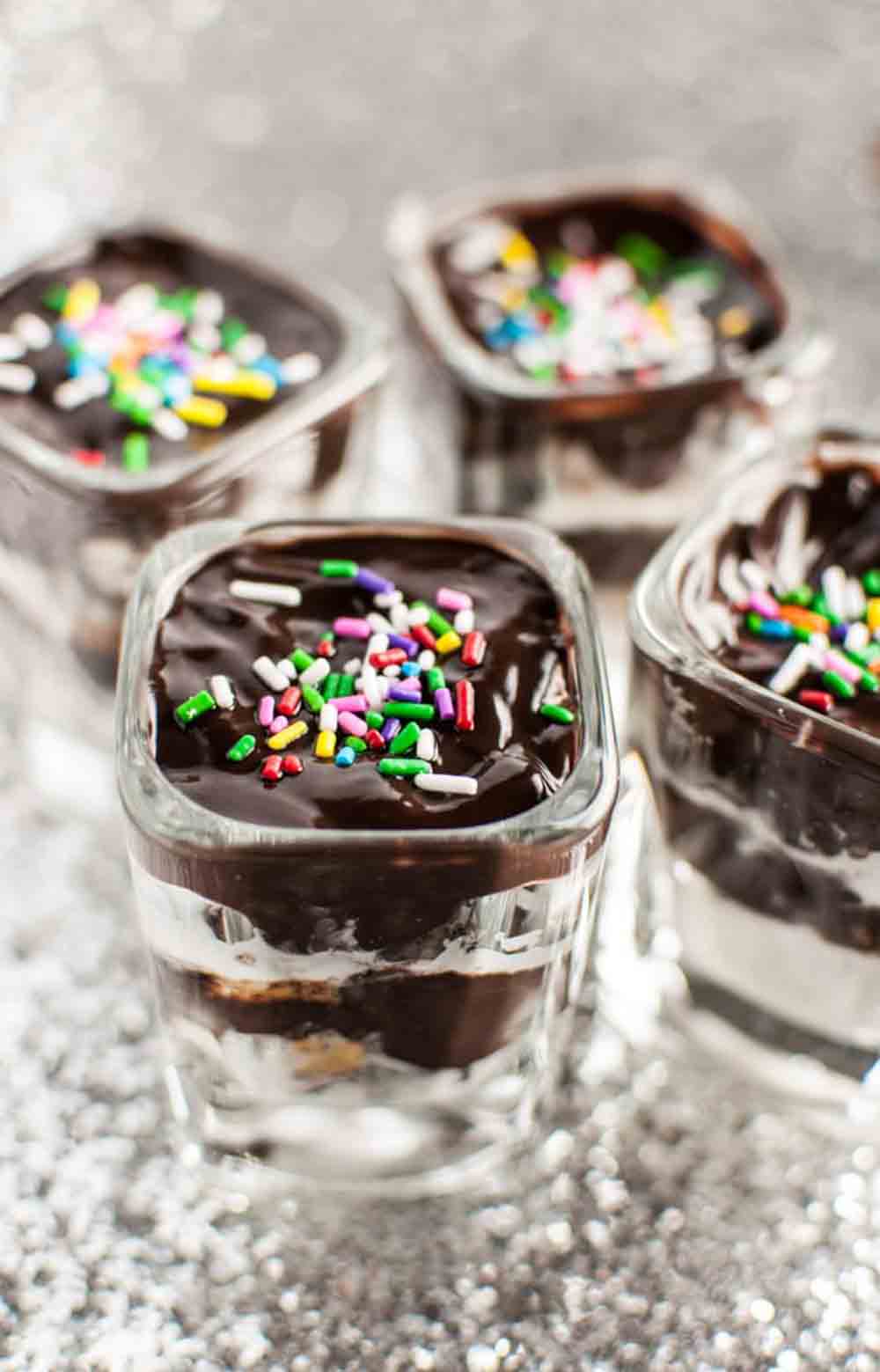 Mini glass cups layered with Oreo, chocolate, and whipped cream, topped with sprinkles — a fun DIY baby shower desserts idea.
