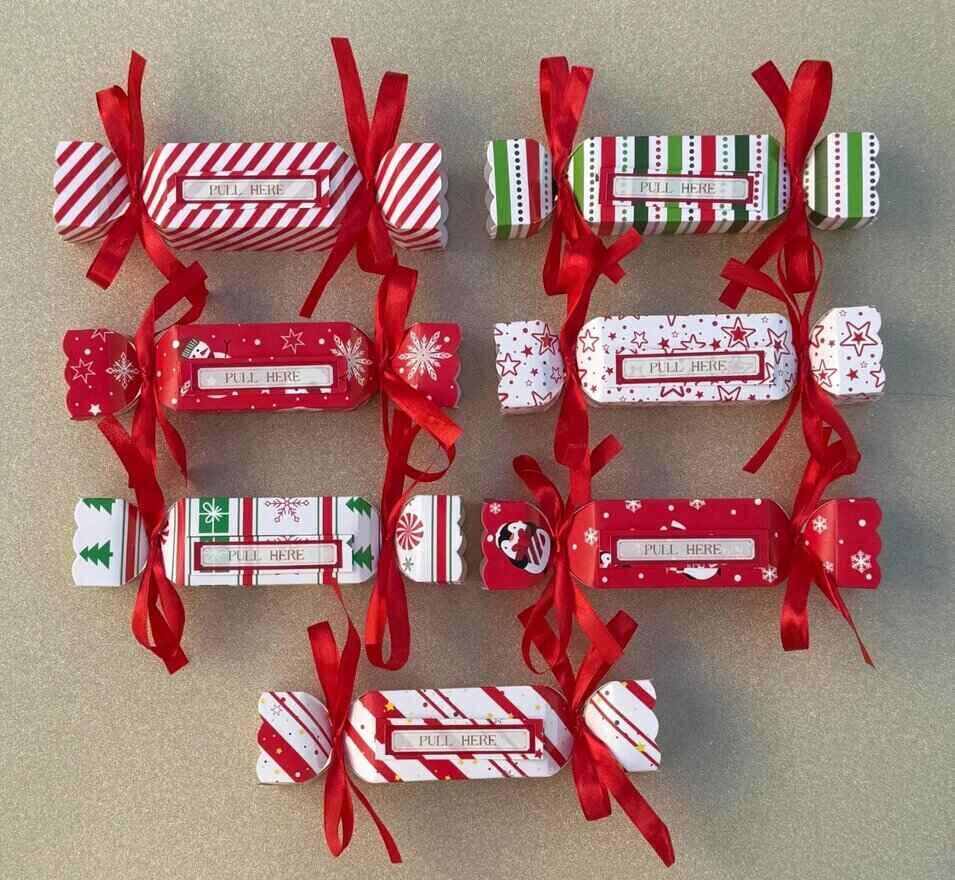 7 pillow boxes shaped like candy with red ribbons tied on the ends. A "pull here" tab is on top of each box, indicating that they should be used to pull out money hidden inside.