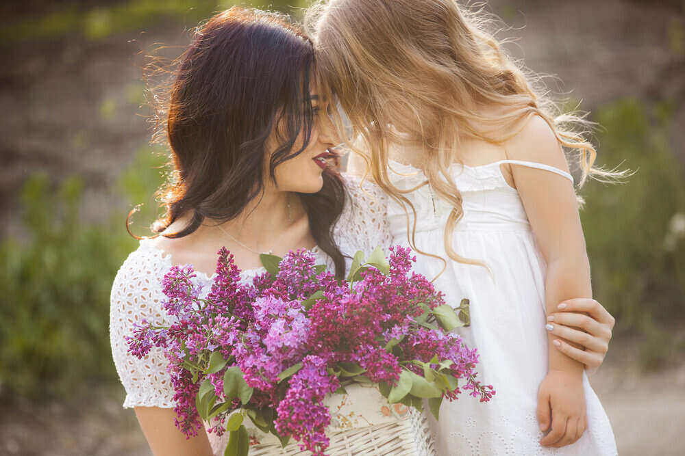 mother and daughter holding a flower bouquet and hugging