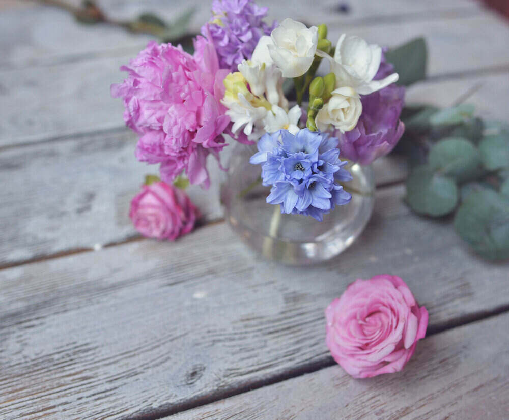 flower arrangement in a clear vase on a wooden background